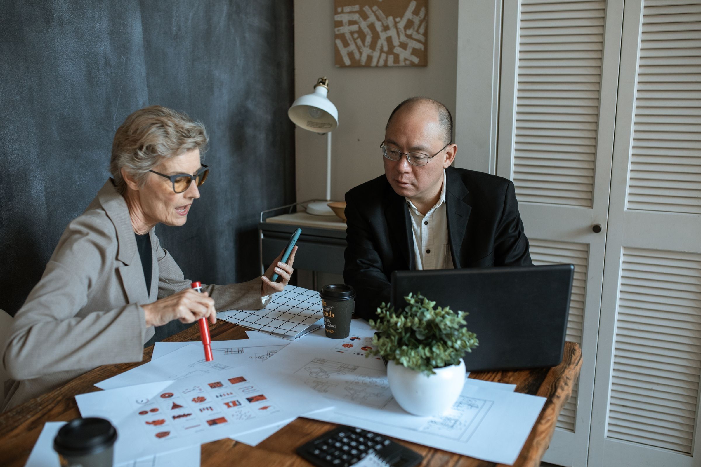 Two professionals collaborating at a desk in a modern office