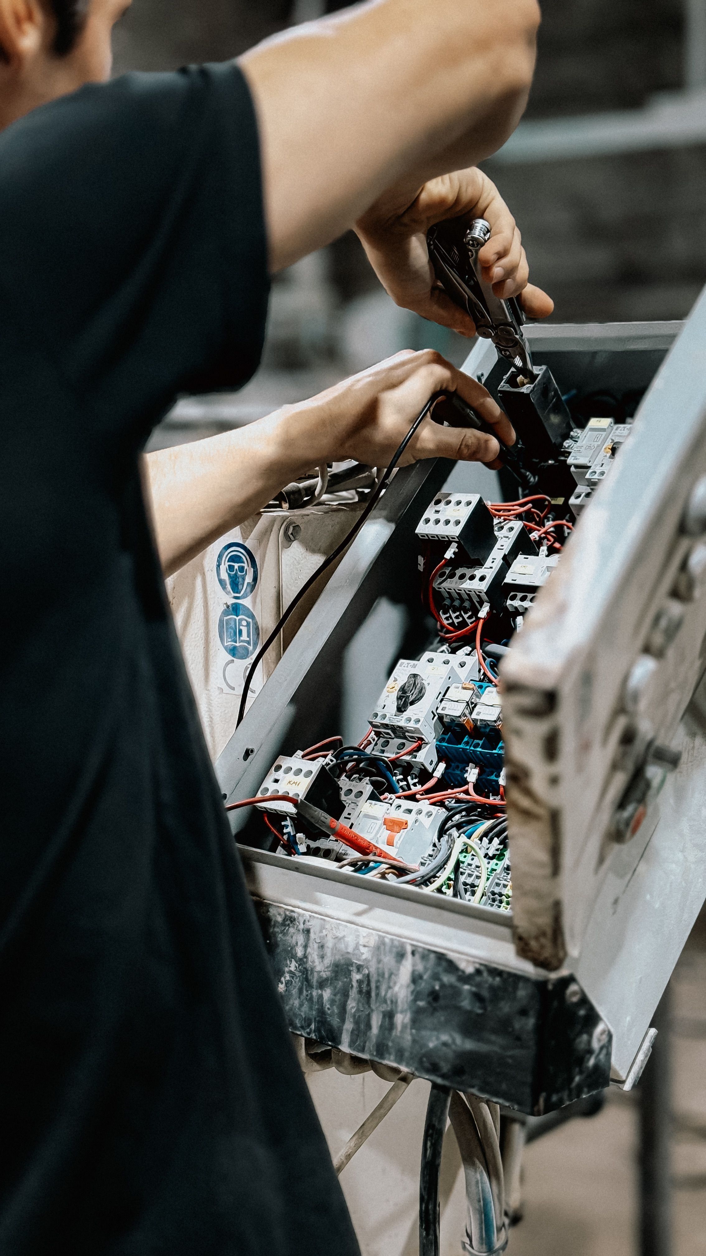A technician adjusting wiring in an electrical control panel