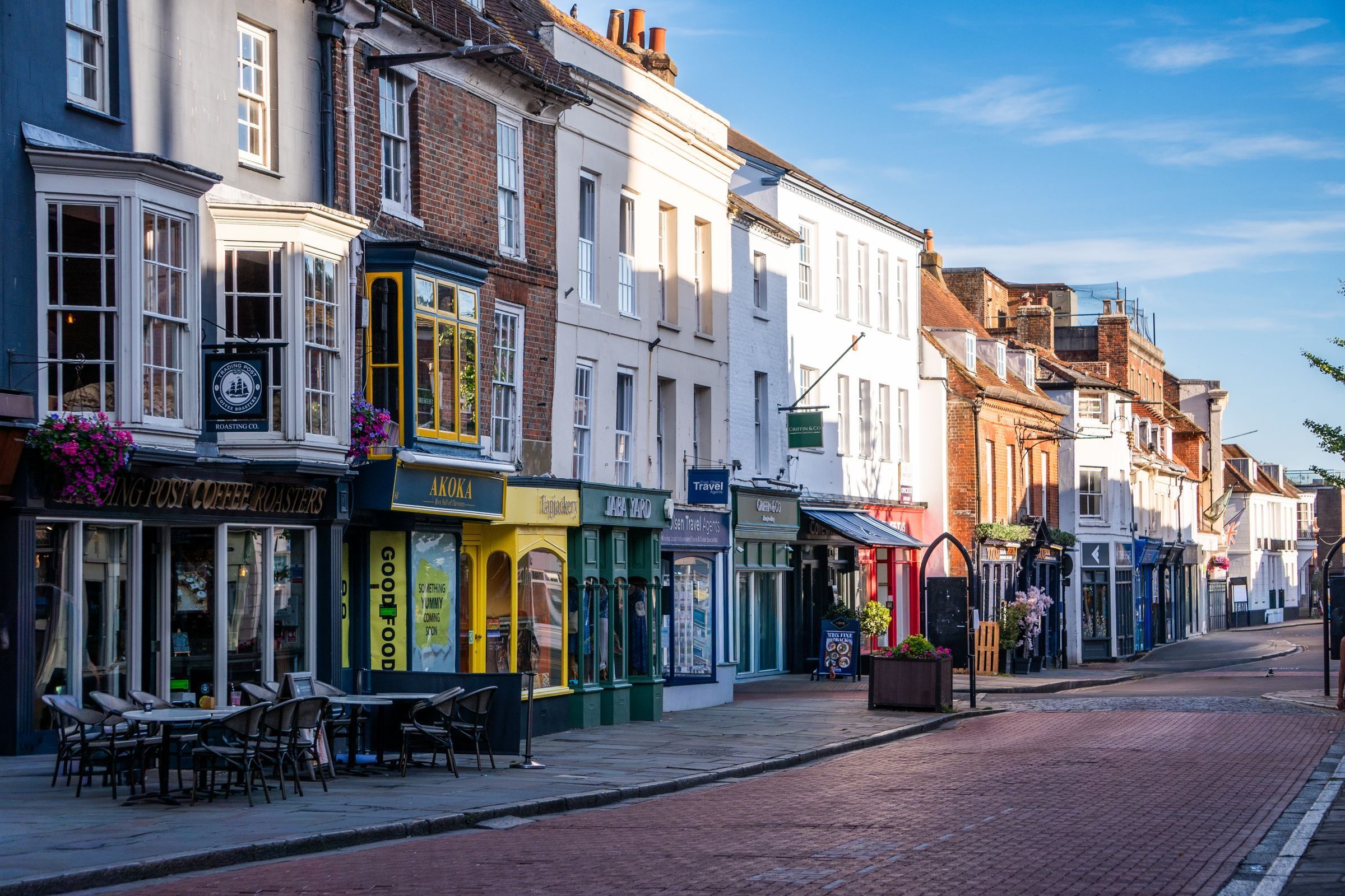A row of colourful shopfronts on an English high street